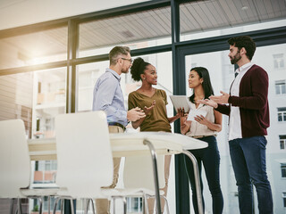 Poster - Discussing the status of business. Shot of a group of colleagues having a meeting in a modern office.