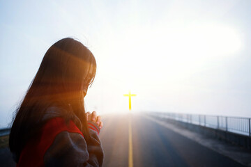 Wall Mural - The girl prays to God and the cross.