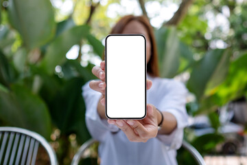 mockup image of a woman holding and showing a mobile phone with blank white screen
