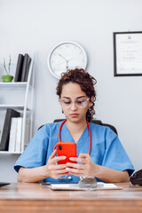 Wall Mural - Doctor latin american woman using a mobile phone.