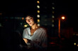 © Lyndon Stratford/peopleimages.com - All day connectivity. Shot of an attractive young woman using a digital tablet outside in the city at night.