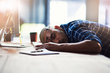 Aufkleber - Slipping out of stress and into sleep. Cropped shot of a young designer sleeping on his office desk.