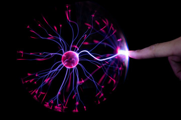 finger touching plasma light ball on black background