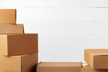 Wall Mural - Group of cardboard boxes against white wooden wall