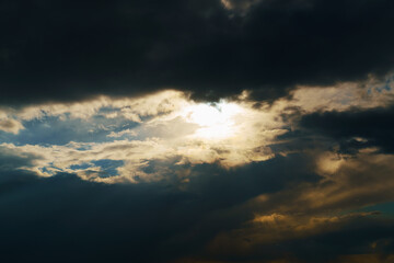 beautiful dramatic sky, bright sunlight and dark silhouette of clouds as background