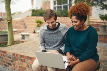Helping each other prep for finals. High angle shot of two young university students using a laptop to study on campus.