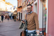 © bnenin - Portrait of elegant, bearded man, leaning on his bike, taking a short break from walking.