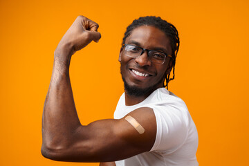 Young black man got vaccinated from coronavirus against yellow background