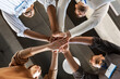 © Syda Productions - business, teamwork and corporate concept - happy smiling colleagues with name tags stacking hands at office