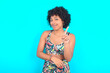 No sign gesture. Closeup portrait unhappy young woman with afro hairstyle in sportswear against blue background raising fore finger up saying no. Negative emotions facial expressions, feelings.