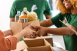 canvas print picture - charity, donation and volunteering concept - close up of volunteers giving box of food at distribution or refugee assistance center
