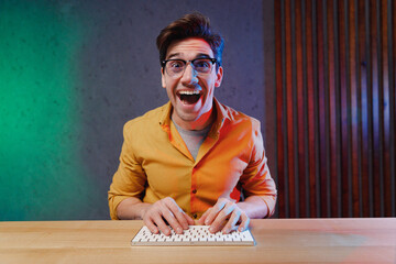 young overjoyed excited geek software engineer it specialist programmer man in yellow shirt touch gl