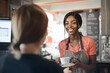 © olly - young waitress serves coffee to a customer
