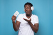 © Viktor Koldunov - African young man with a retro cassette does not know what to do with it.