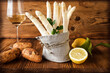 Bunch of white asparagus with ingredients on rustic wood. Background for a seasonal gastronomy concept with space for text