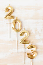 Numerals 2023 In Gold Color In A Vertical Arrangement On A White Wooden Table Top View, Flat Lay.