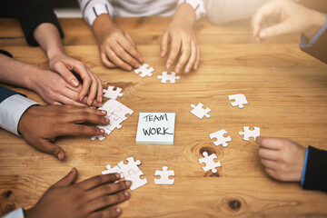 Poster - Planning it all out, piece by piece. High angle shot of a group of unrecognizable coworkers building a puzzle on their boardroom table.