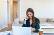 © Graphicroyalty - Shot of a businesswoman on a video call while sitting at her desk.Cropped shot of an attractive young woman using her laptop to make a video call at home