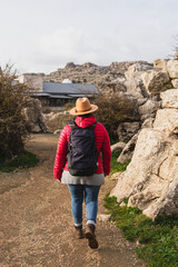 Back shot of Caucasian woman wearing backpack and walking in El Torcal de Antequera, Malaga, Spain