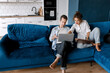 © shunevich - Image of successful young couple man and woman working on laptops together while sitting on coach at home. Happy spouses in love have success in new project with happiness and good emotion