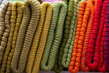 Stack Of Different Colorful Folded Knitted Scarfs Texture. Stylish Fall-winter Season Knitwear Clothing