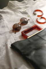 Wall Mural - Striped shirt, leather bag, brown sunglasses and tortoiseshell pattern sunglasses. Selective focus.