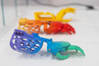 Samples of multi-colored children's prosthetic hands made of 3D plastic.