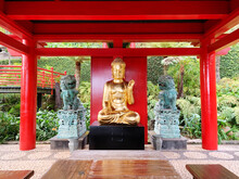 Golden Statue Of Buddha Under A Red Wooden Pavilion Located In Monte Palace Madeira Park