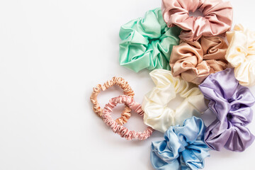 Collection of trendy silk elastic bands scrunchies on white background. Diy accessories and hairstyles concept, luxury color