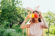 © Serenkonata - Cute funny girl with Easter eggs and bunny ears at garden. easter concept. Laughing child at Easter egg hunt. Child in park with basket full of eggs, spring concept