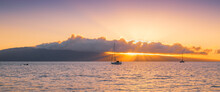 Rays Of Light From Colorful Sunset Beneath Clouds Over An Island And Sailboats - Panorama View Of Lanai From Kaanapali Beach In Maui