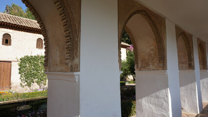 The arched hallway and the garden of Alhambra Palace in Granada, Andalusia, Spain