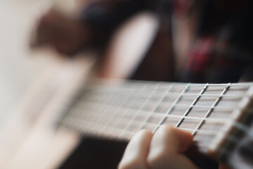 Selective soft focus, close up hands teenager girl learning to play guitar. copy space