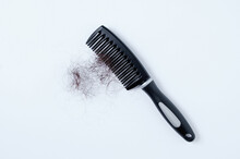 Bunch Of Hair On A Black Comb. White Background.