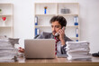 © Elnur - Young male employee unhappy with excessive work in the office