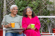 © Photographielove - happy senior couple in the garden having cup of coffee