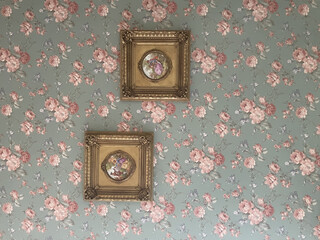 Closeup shot of two vintage square photo frames on a floral patterned background