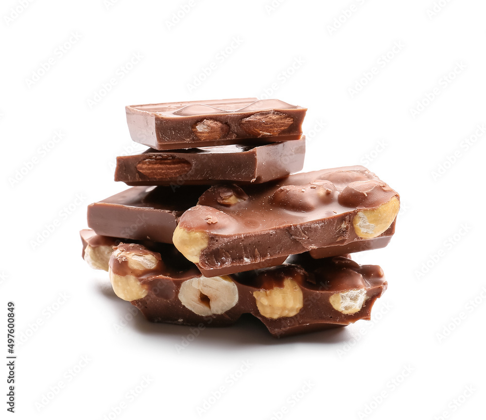Pieces of tasty chocolate with hazelnuts on white background