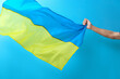 © Pixel-Shot - Male hand with national flag of Ukraine on color background