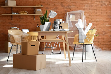 Wall Mural - Cardboard boxes with belongings and furniture in interior of office on moving day