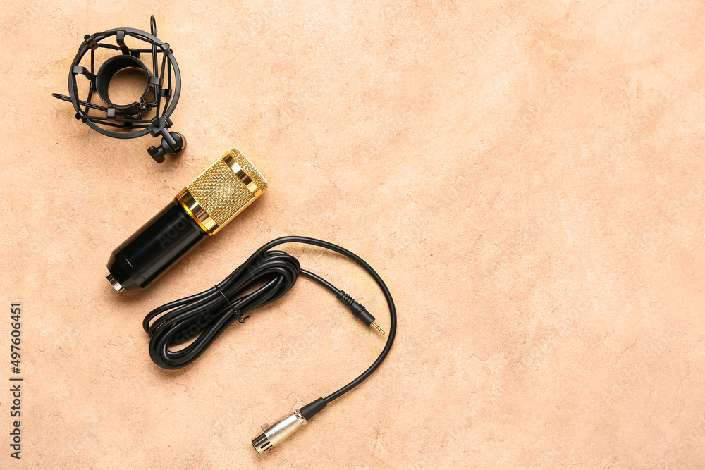 Modern microphone with stand and wire on color background