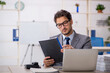 © Elnur - Young male employee sitting at workplace