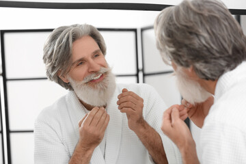 Canvas Print - Mature man taking care of his beard and mustache in bathroom