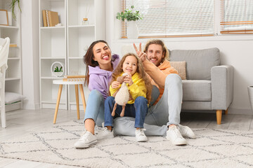 Poster - Young family sitting on soft carpet at home