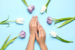 © Pixel-Shot - Female hands with beautiful manicure and tulips on blue background