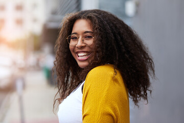 Wall Mural - Im your favourite city girl. Cropped portrait of a happy young woman standing outdoors in an urban setting.