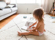 © Maria Manco/Stocksy - girl sits on floor with book