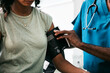 © Sean Locke/Stocksy - Exam: Woman Has Blood Pressure Tested