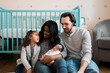 © Maria Manco/Stocksy - New family of four with newborn baby