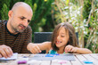 © Daniel Gonzalez/Stocksy - Father with daughter collecting game pieces